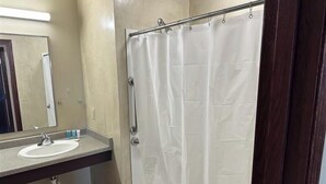 A bathroom with a white bathtub, a sink, and a mirror. - Apartment Centrally Located (Plymouth)