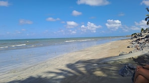 A beach with clear skies, calm waters, and scattered rocks. - João Feitosa Housing Complex (Nossa Senhora da Conceição Paulista)