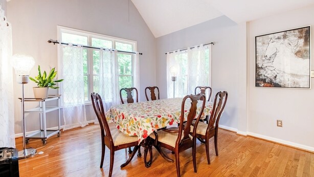A dining room with a wooden table and chairs, large windows, and a ceiling fan. - Spacious 4BR Getaway w/ Games, Pier & Firepit (King and Queen Court House)