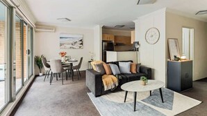 En moderne stue med sofa, sofabord og spiseområde.