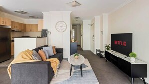 En moderne stue med sofa, sofabord og fjernsyn.