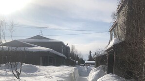 A snow-covered residential street with houses on either side.