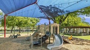 A playground with slides, climbing structures, and a covered area. - RENOVATED-Vacation Cabin, Riverfront - Hunt, TX (Ingram)