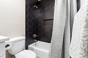 Een haardroger, handdoeken, zeep, toiletpapier