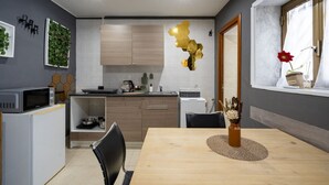 Una cocina moderna con armarios de madera, una mesa de comedor con sillas y una ventana con un jarrón de flores.