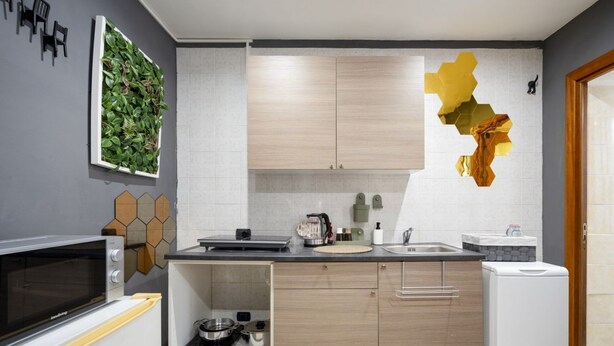 Una cocina moderna con armarios blancos, microondas, fregadero y refrigerador.