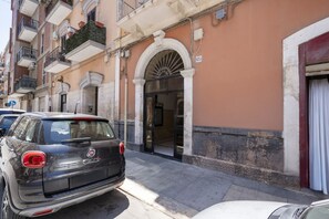 A building with a classic architectural style, featuring a large arched entrance and a balcony with plants. - Casa Ravanas - City Center Studio (Bari)