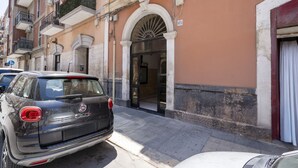 Un edificio de estilo arquitectónico clásico, con un amplio arco de entrada y un balcón con plantas.