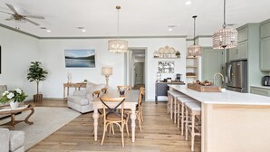 A modern kitchen with a central island, wooden chairs, and pendant lighting. - The Magnolia Ridge Retreat (Jasper)