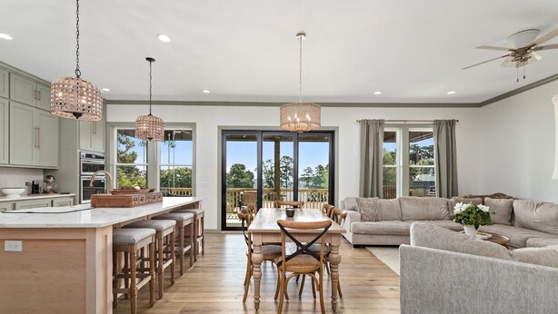 A spacious living area with a dining table, sofas, and a kitchen with a large island. - The Magnolia Ridge Retreat (Jasper)