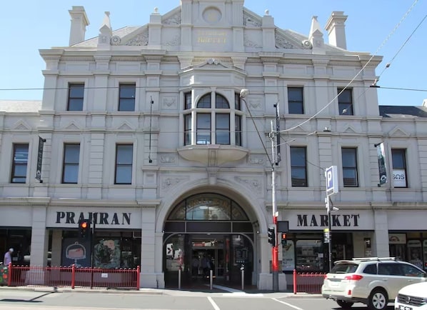 A historic building with a prominent arch entrance, labeled 'PRAN MARKET' on the facade.