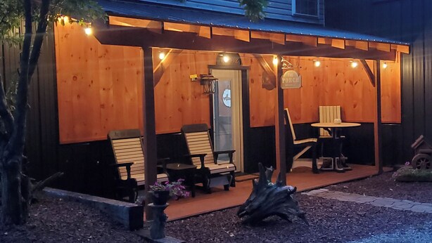 Une façade en bois, une terrasse couverte, des sièges extérieurs et une enseigne indiquant qu’il s’agit d’un restaurant.