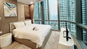 Habitación de hotel moderna con una cama grande, televisión de pantalla plana y vistas a la ciudad.