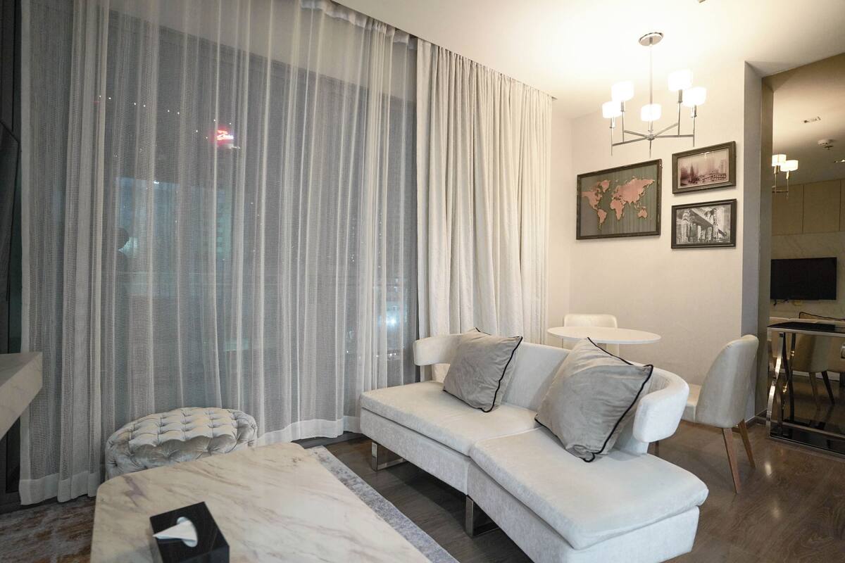Une chambre d’hôtel moderne comprenant un canapé, une petite table ronde, un lit et un coin repas.