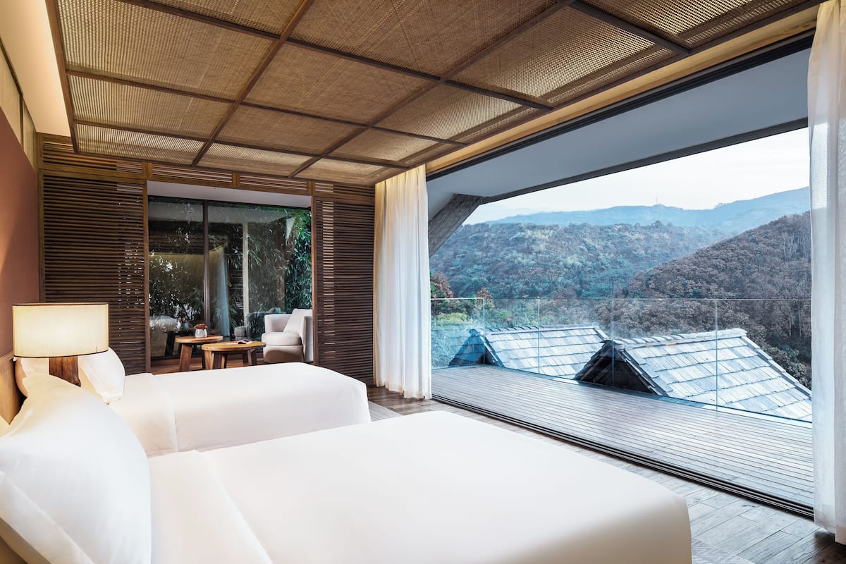Una moderna camera d'albergo con un letto grande, una scrivania e vista sulle montagne.