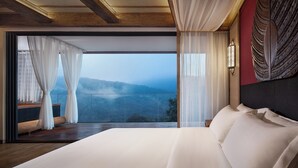 A bedroom with a large bed, a view of a mountainous landscape, and a wooden ceiling. - Jinghong Bood Panorama Resort Inn (Xishuangbanna Dai)