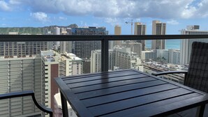 A balcony with a view of a cityscape, including high-rise buildings and a construction crane. - Diamondhead & Ocean View ISLAND COLONY, Central location Walk to the beach, AC (Honolulu)