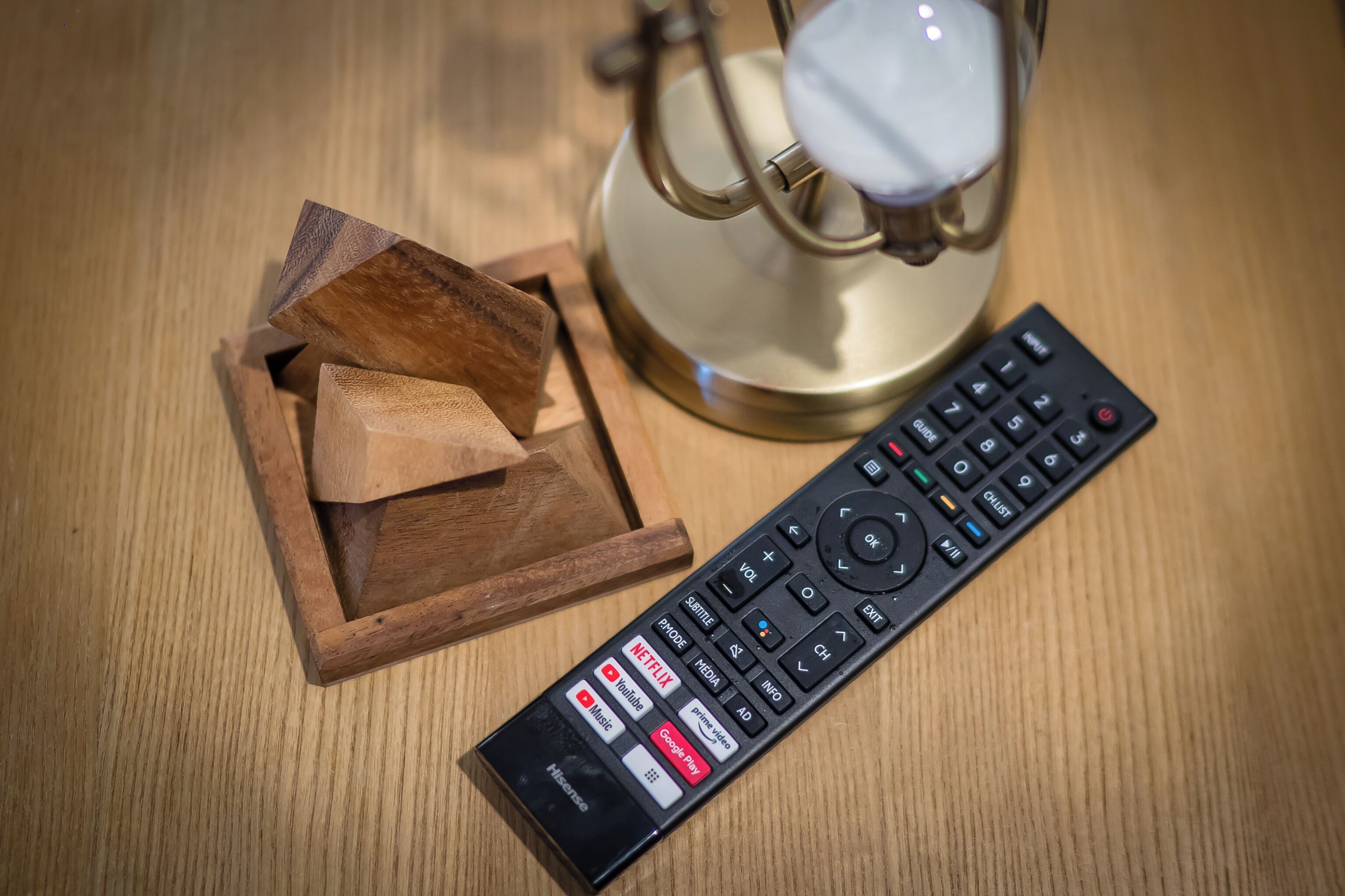Une télécommande et un bloc de bois sur une surface en bois.