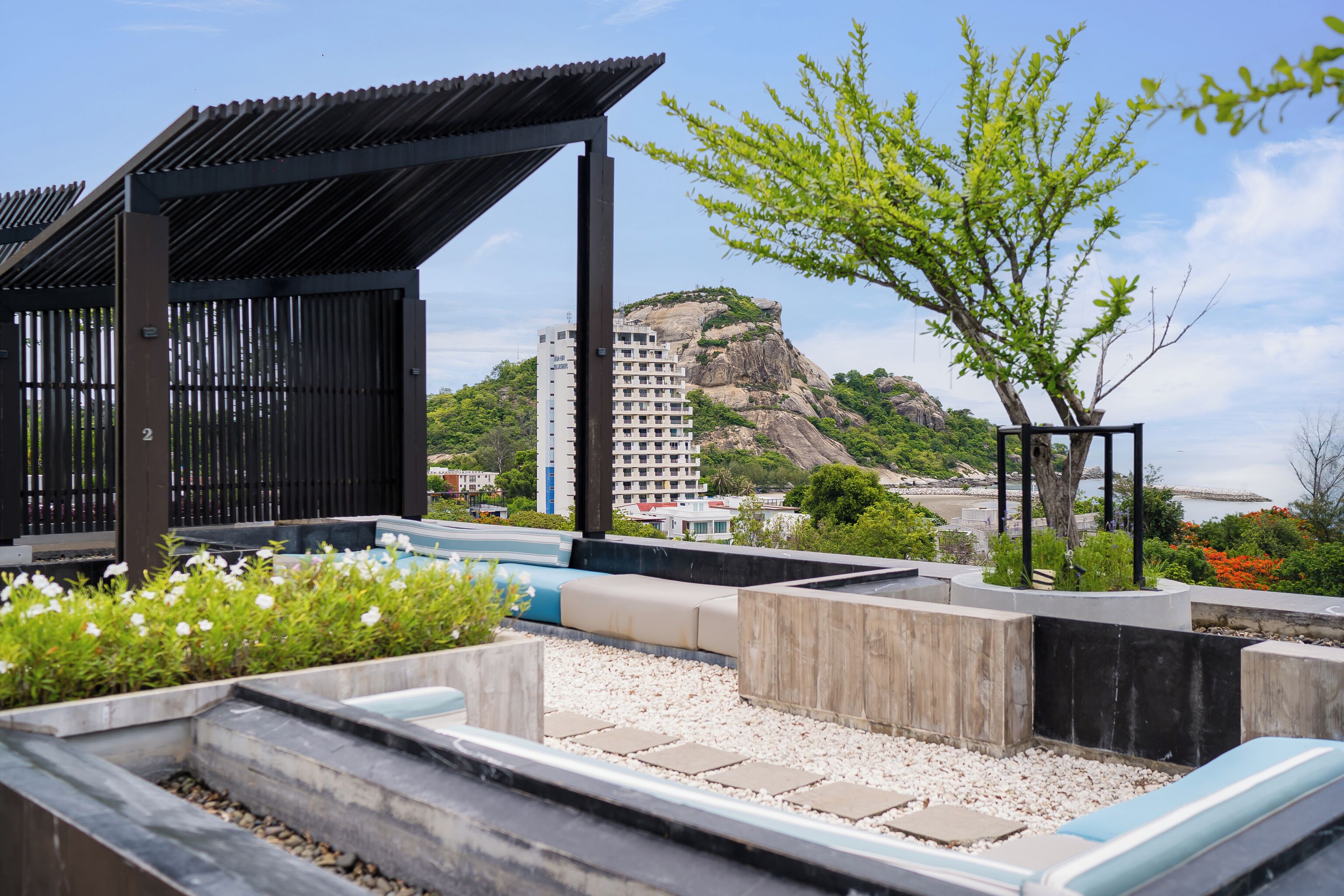 Una terraza en la azotea con vistas a una montaña y un edificio.