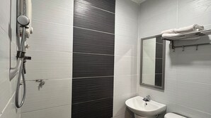 Une salle de bain moderne équipée de toilettes, d’un lavabo et d’une douche.