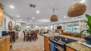 A spacious kitchen with granite countertops, a large stove, and a dining area with wooden chairs. - Florida Riverfront Sunrise | Fish, Boat, Unwind (Jacksonville)