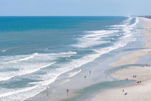 A wide beach with gentle waves and a clear sky. - Gameroom, Pool & Pickleball Access, Summer Fun (Jacksonville)