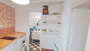 A compact kitchen with a washing machine, a wooden countertop, and a tiled backsplash. - Alhambrita. Cool and quiet house with wifi to disconnect. (Viznar)