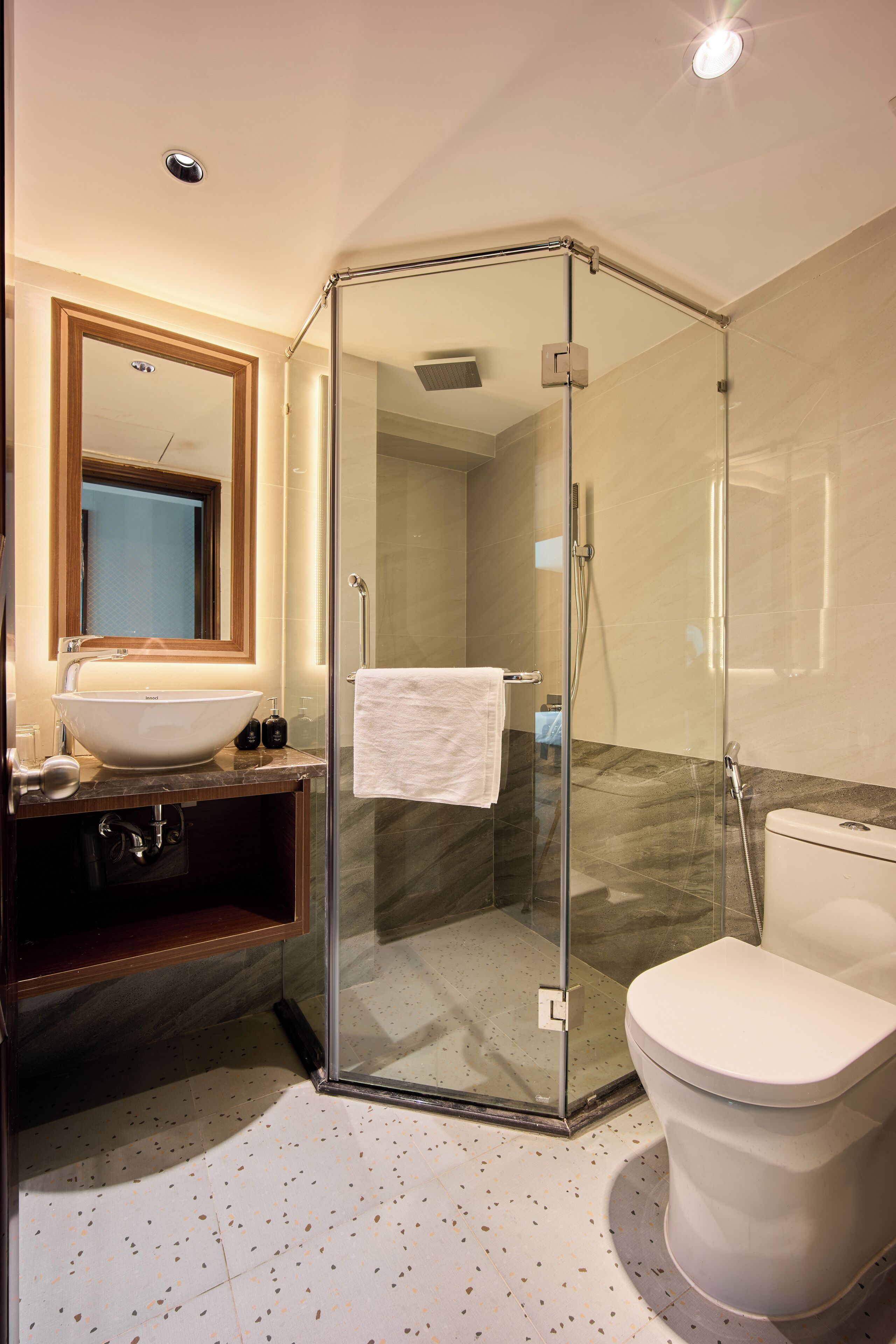 Une salle de bain moderne avec une douche à parois de verre, un lavabo blanc et des toilettes.