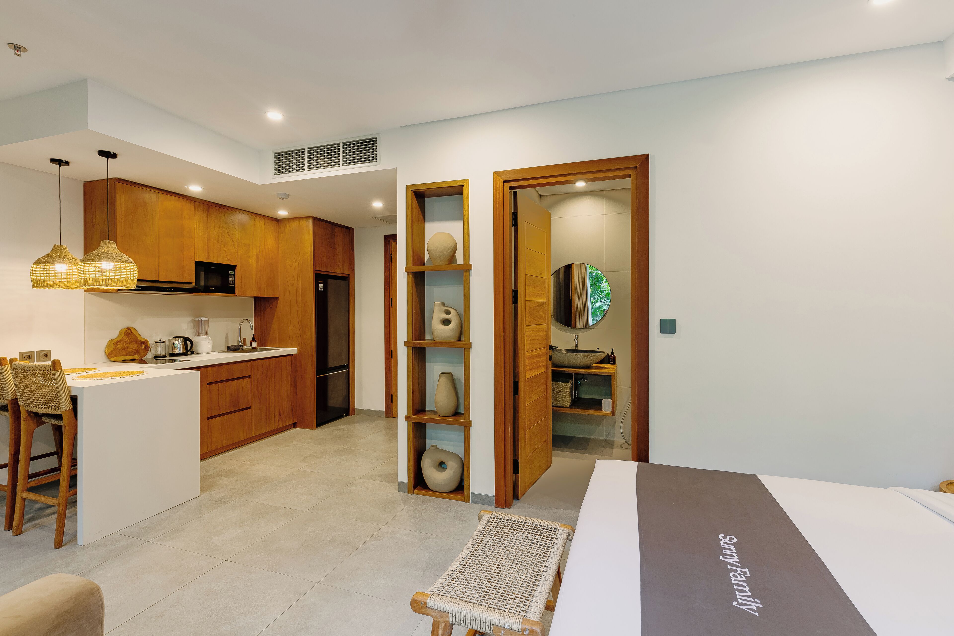 Una cocina moderna con armarios de madera, una isla central y un comedor con sillas.