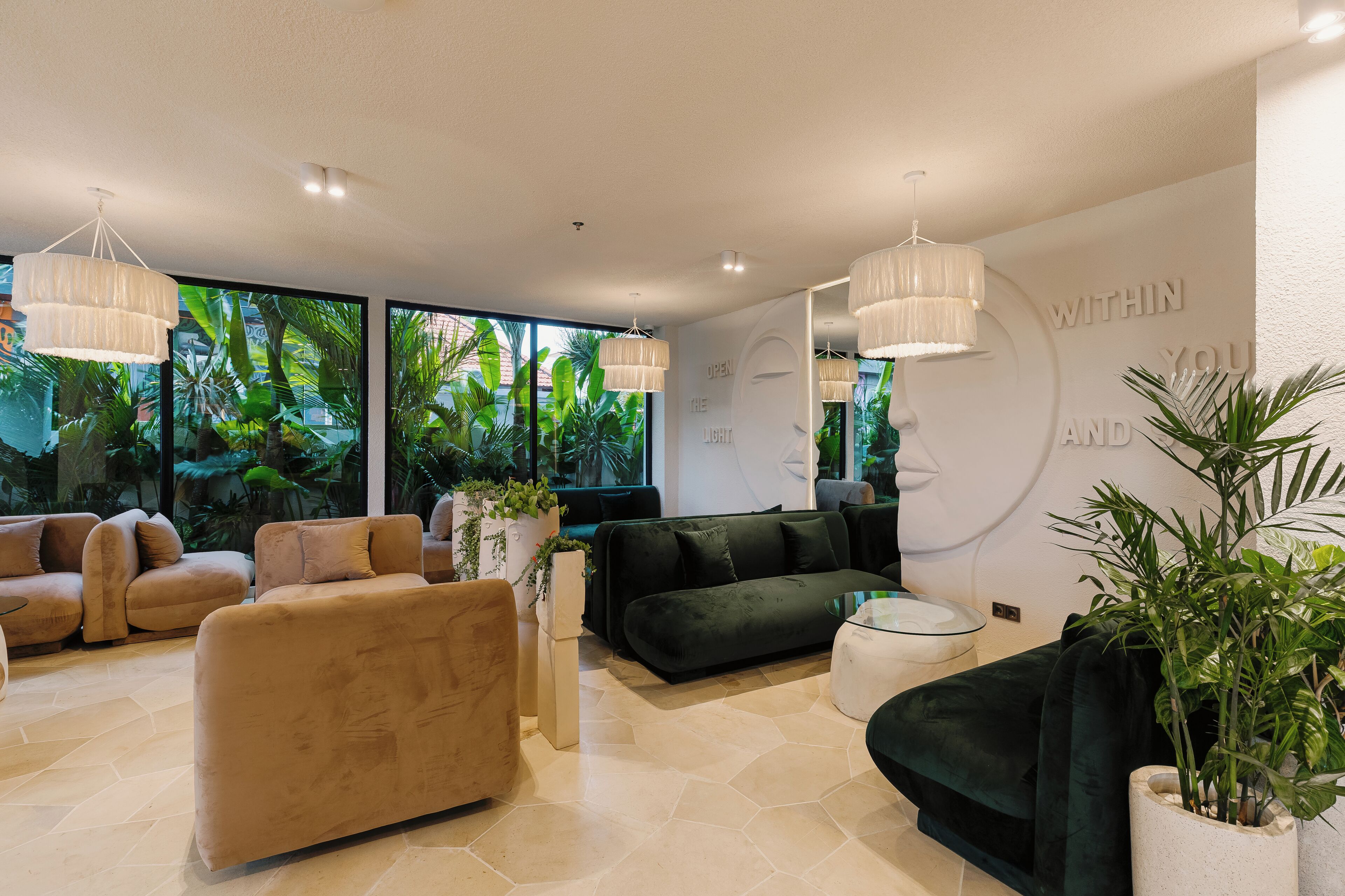 A modern living room with large windows, a black sofa, beige sofas, and a coffee table.