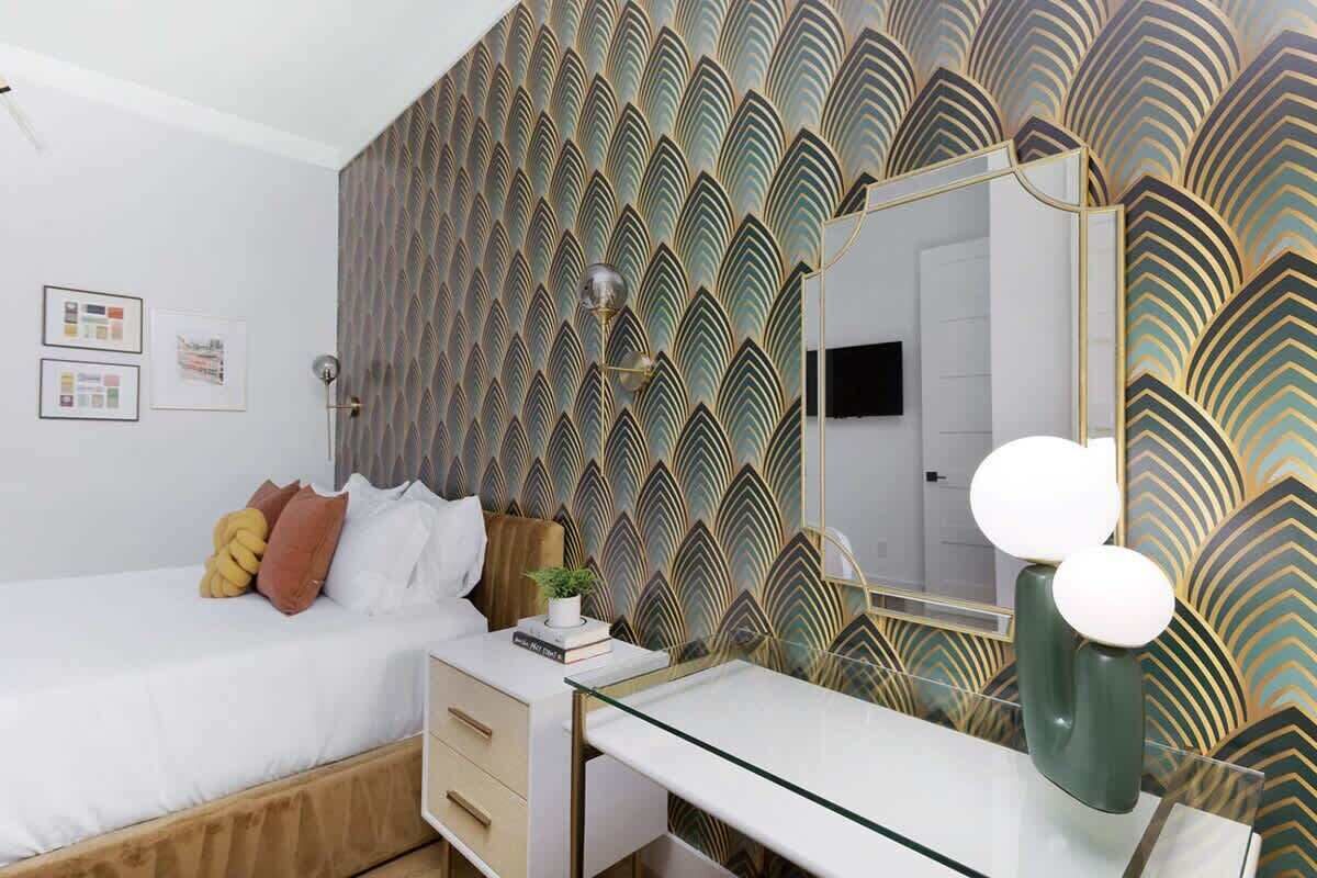 Une chambre à coucher comprenant un lit, une table de chevet, une commode et un grand miroir au design moderne.