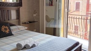 A bedroom with a bed, a mirror, a window, and a view of the outside. - Da Nina (Lascari)