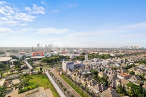 An aerial view of a cityscape with residential buildings, a stadium, and a large red structure.