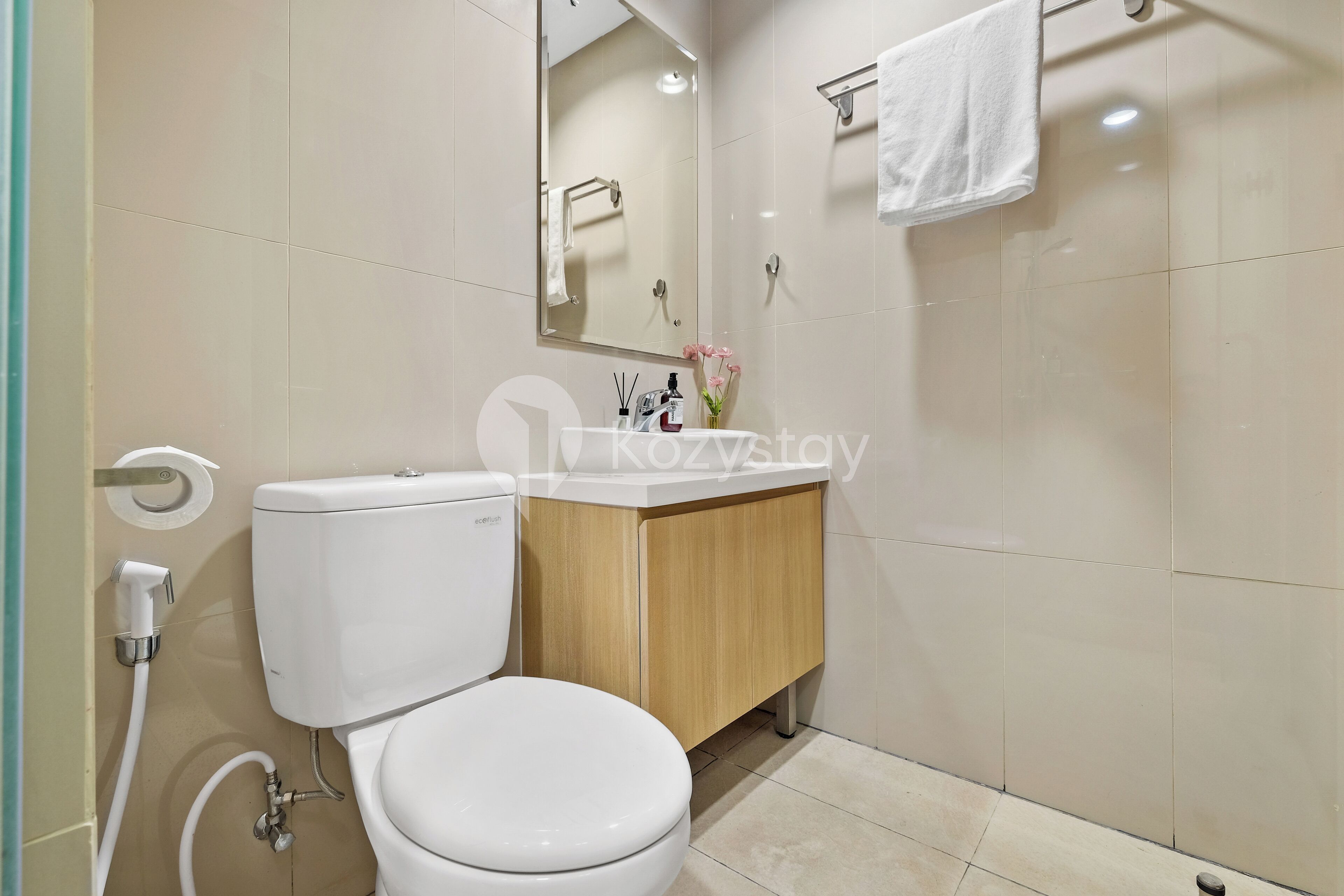 A modern bathroom with a toilet, sink, and mirror.