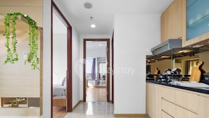 A modern kitchen with wooden cabinets, a black countertop, and a built-in stove.