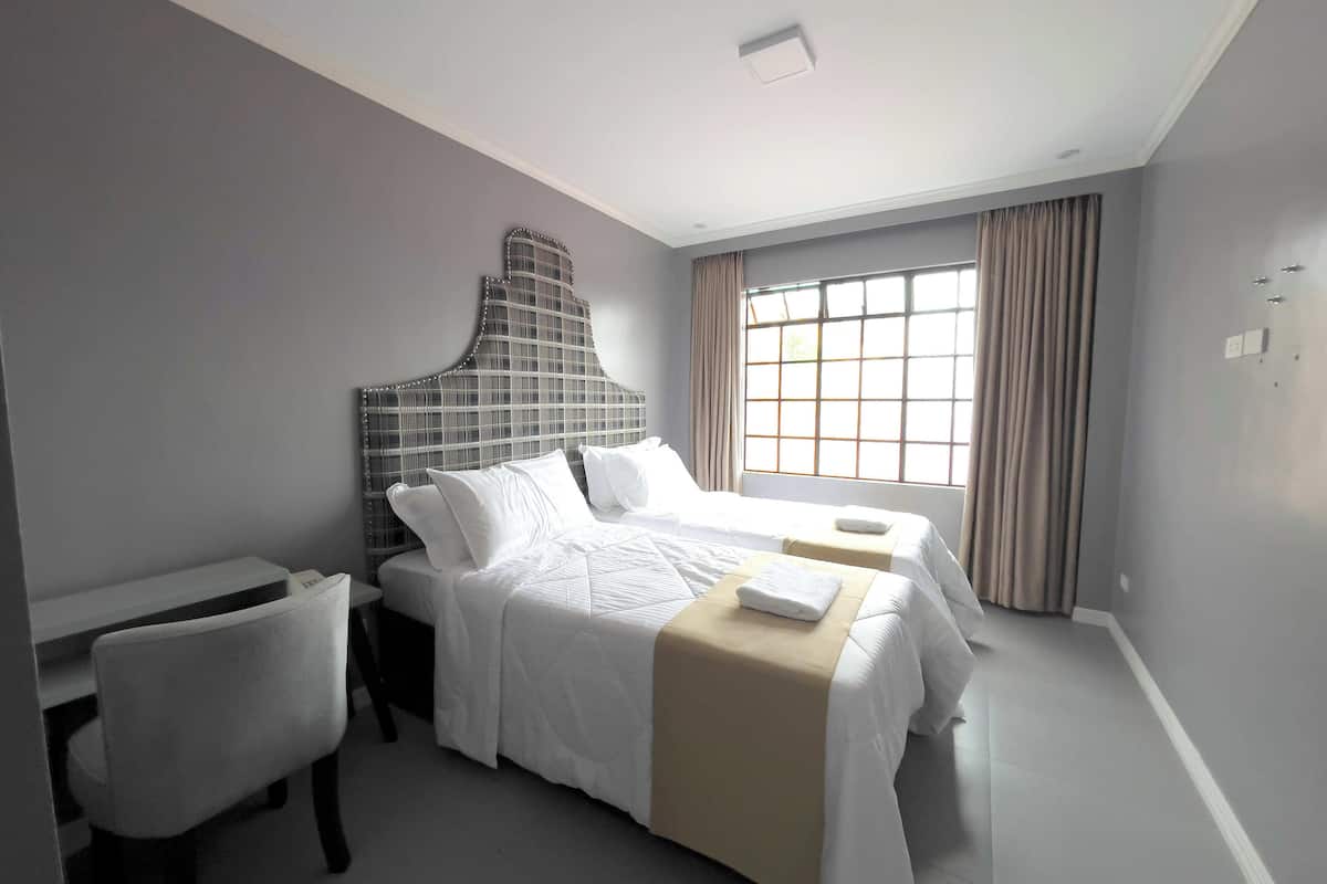 Ein Hotelzimmer mit einem großen Bett, einem Schreibtisch und einem Stuhl.