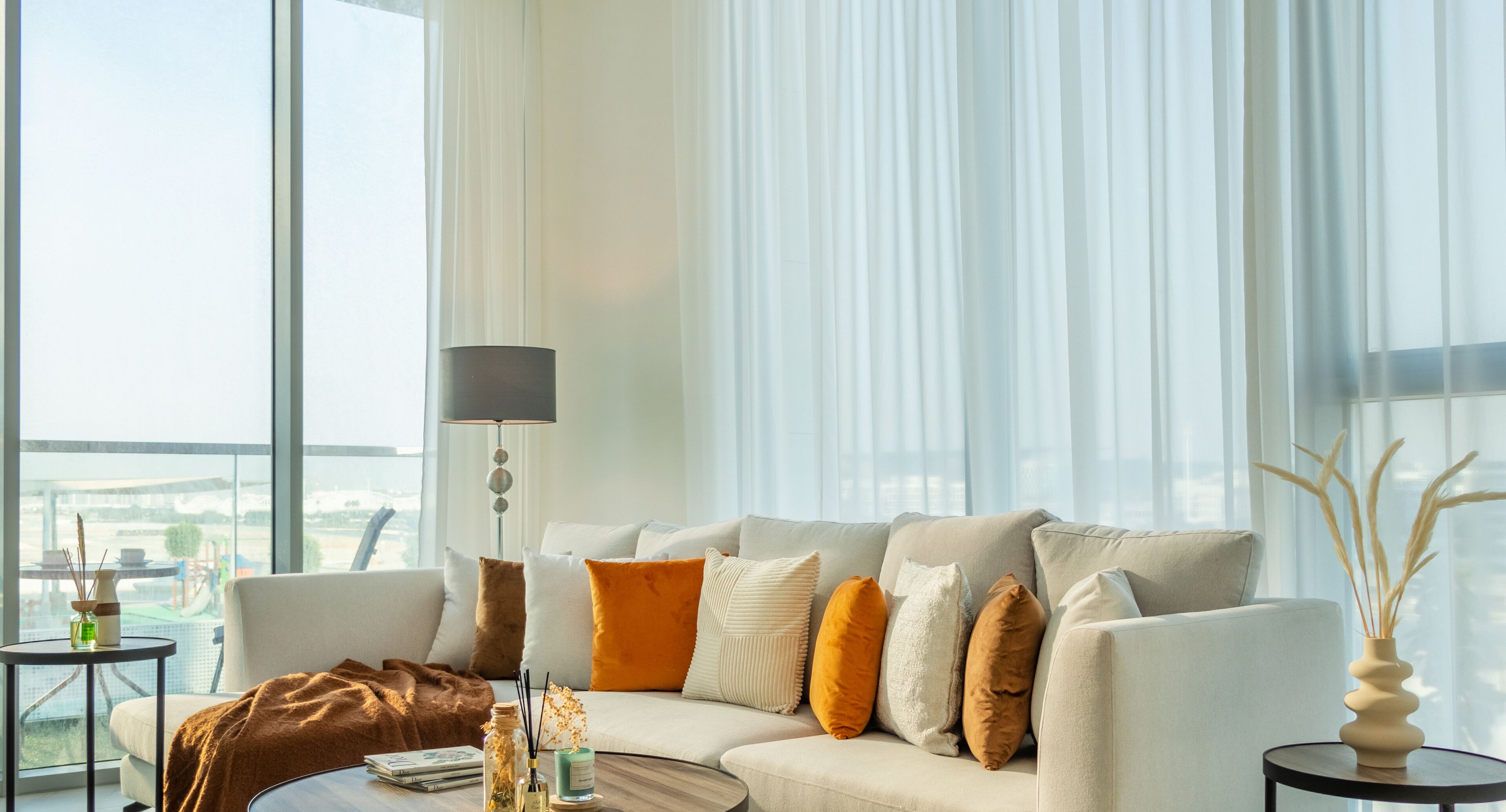 Un salon moderne avec un canapé, une table basse et une lampe.