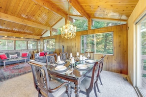 A wooden interior with a dining table set for six, surrounded by six chairs.