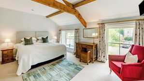 Een slaapkamer met een bed, bureau, stoel en uitzicht op buiten.