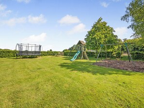 A playground with a slide, swings, and a climbing structure. - Doxford House - UK49888 (Doxford, near Embleton)