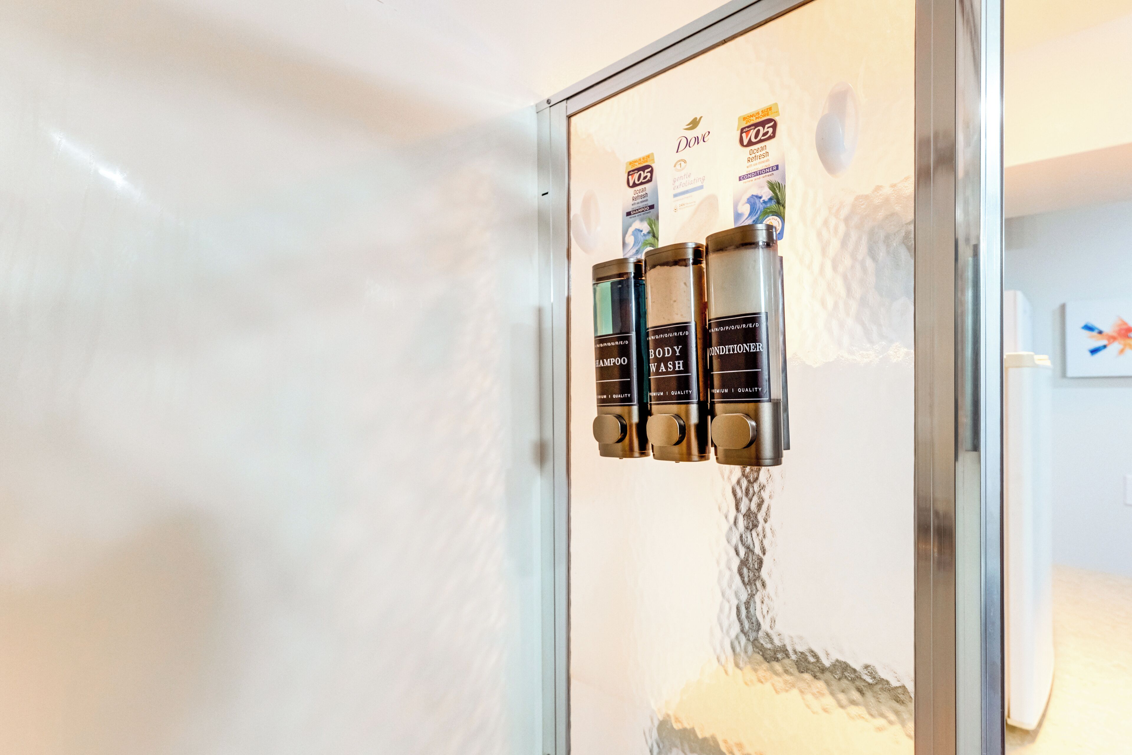A shower with multiple bottles of Dove body wash and conditioner.