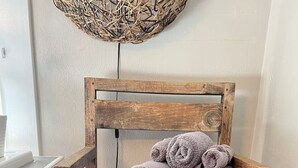 Una sedia di legno rustica con un arazzo intrecciato appeso sopra.