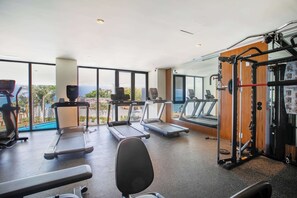 Un gimnasio con cintas de correr, una banca para pesas y una estructura para sentadillas.