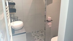 A bathroom with a shower, a sink, and a toilet.