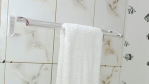 A bathroom with a white towel hanging on a metal rack. The walls have a fish pattern. - Kili Share Hotel & Hotel (Himo)