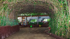 An indoor covered walkway with brick walls and a metal railing. - Kili Share Hotel & Hotel (Himo)
