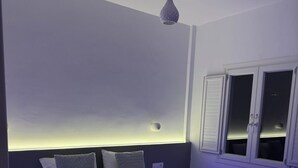 A modern bedroom with a bed, bedside tables, and a window with shutters. - Διαμέρισμα 1 Υπνοδωματίου (Καμάρι)