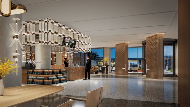 Eine moderne Hotellobby mit einer Rezeption, einer Sitzecke und einem großen digitalen Bildschirm, der den Namen des Hotels anzeigt.