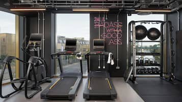 A gym with treadmills, a rowing machine, and a weight rack.