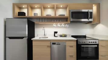 A modern kitchen with a refrigerator, microwave, dishwasher, stove, and cabinets.